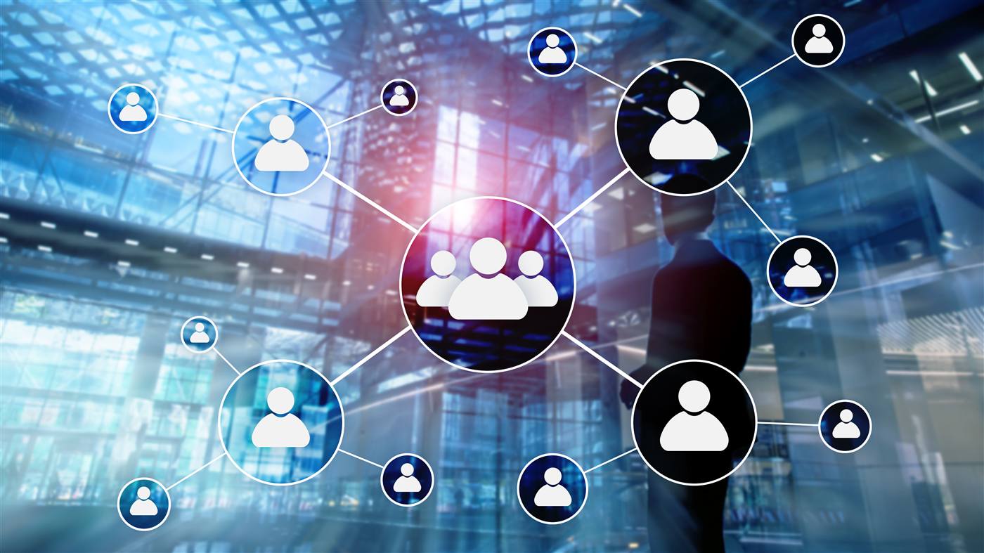 Suited silhouette in a modern glass-and-steel atrium with an overlaid network diagram of connected person-icon nodes.