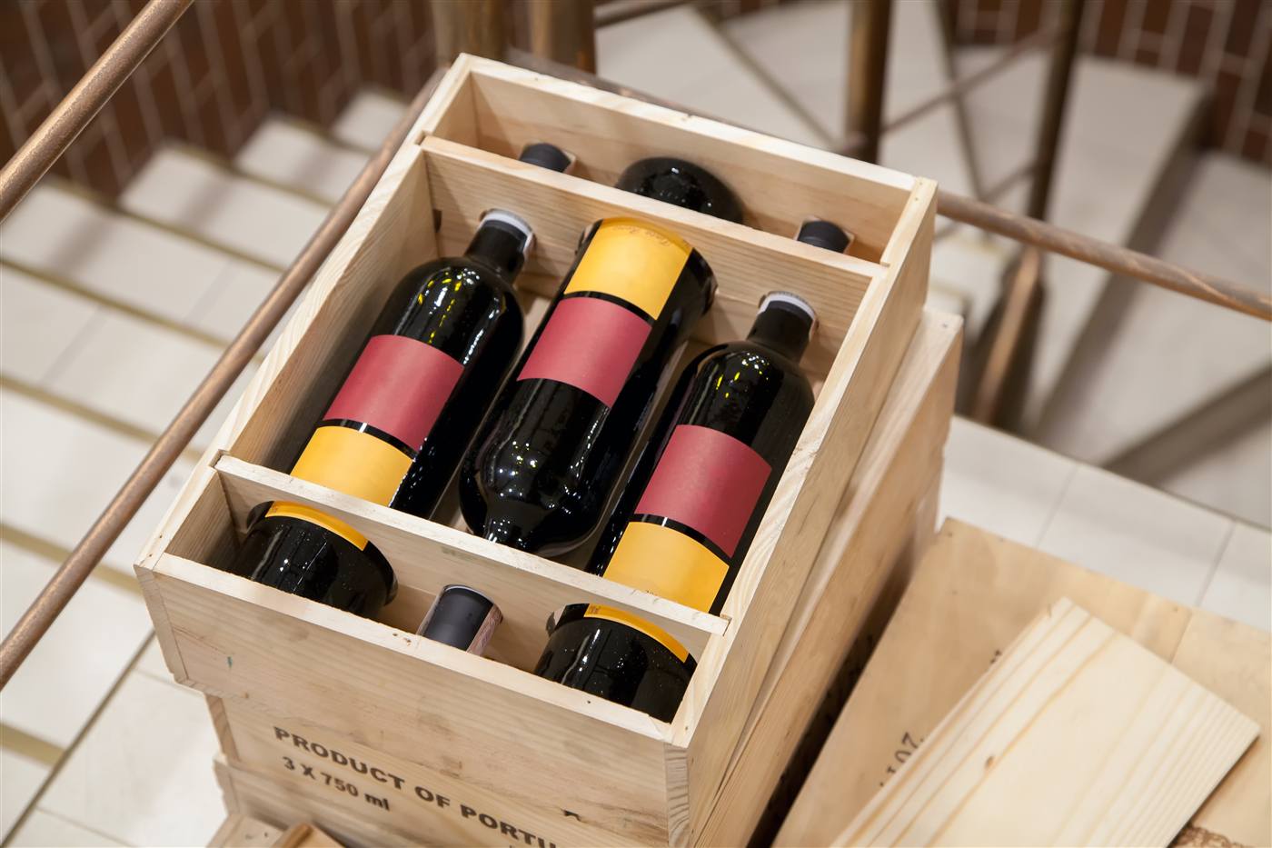 Overhead view of two open wooden crates each holding six horizontally stacked wine bottles labelled Product of Portugal.